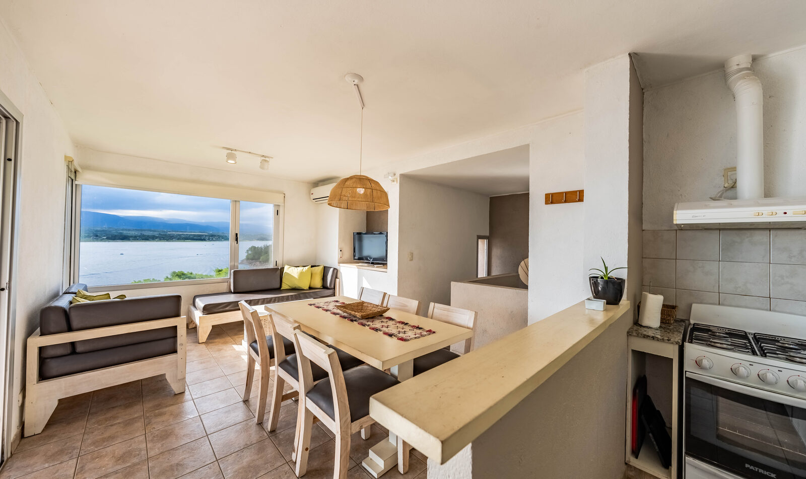 Cocina integrada al comedor de la casa, con el Lago Los Molinos por el ventanal