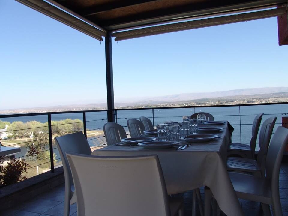 Mesa puesta en la galería de una Casa de Lago, con el Lago Los Molinos de fondo