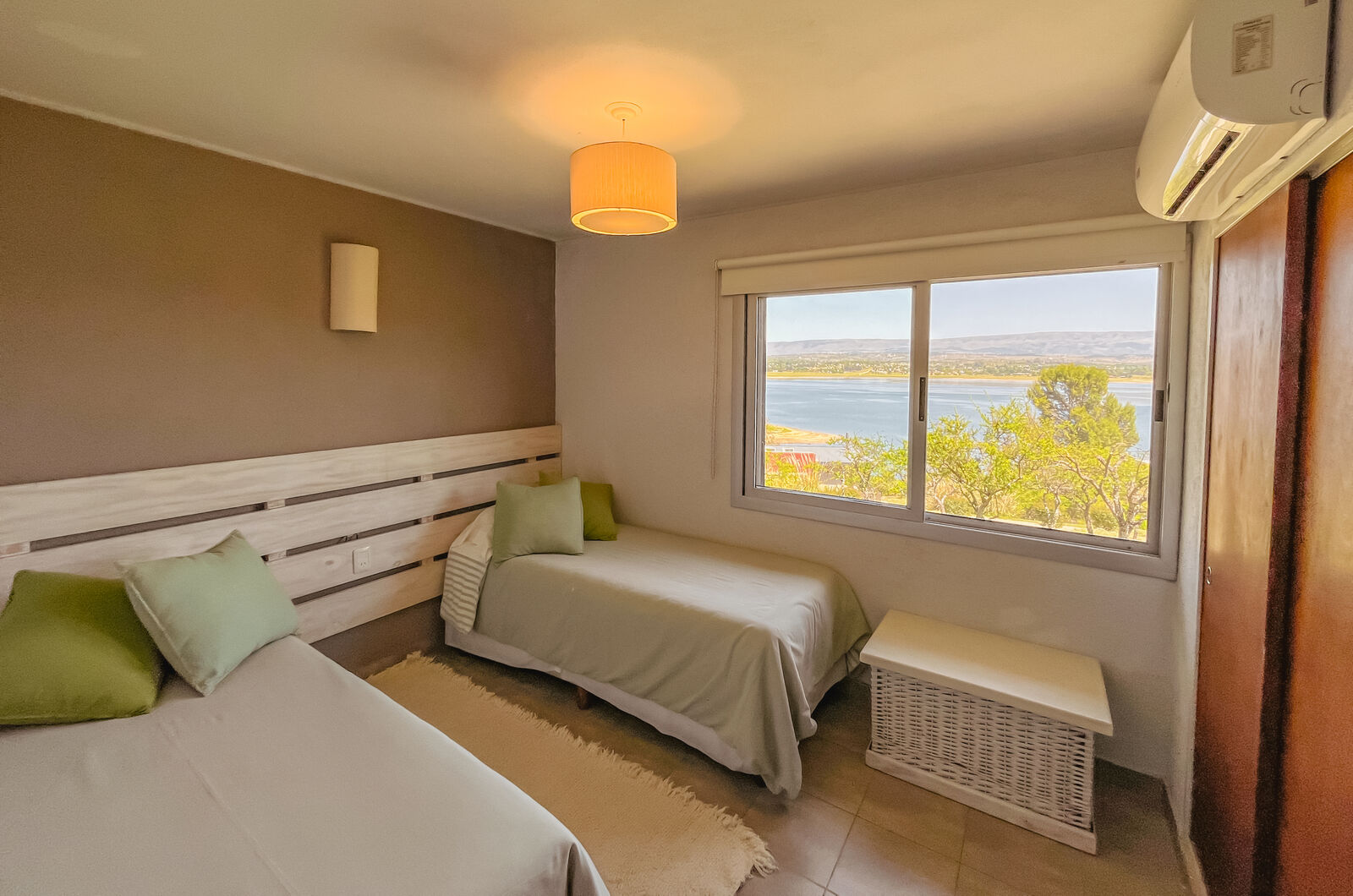Segundo dormitorio de una Casa de Lago, con dos camas y el Lago Los Molinos por la ventana