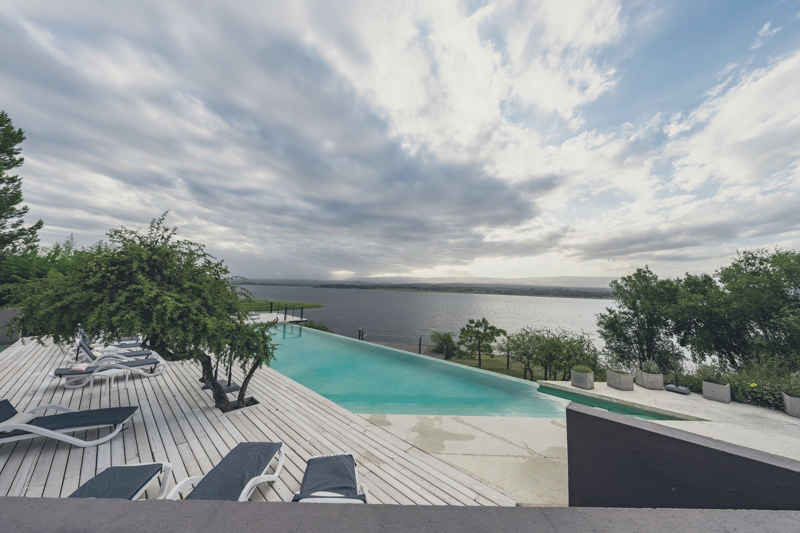 O deck da piscina com espreguiçadeiras, na orla