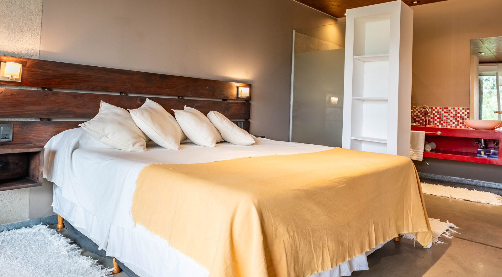 A cama do estúdio junto à janela ampla para o lago