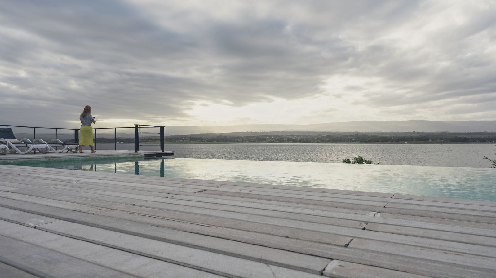 A piscina infinita ao pôr do sol, com o lago aceso