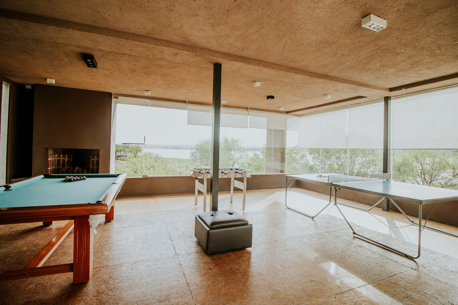 A sala de jogos com mesa de bilhar e janelas amplas para o Lago Los Molinos