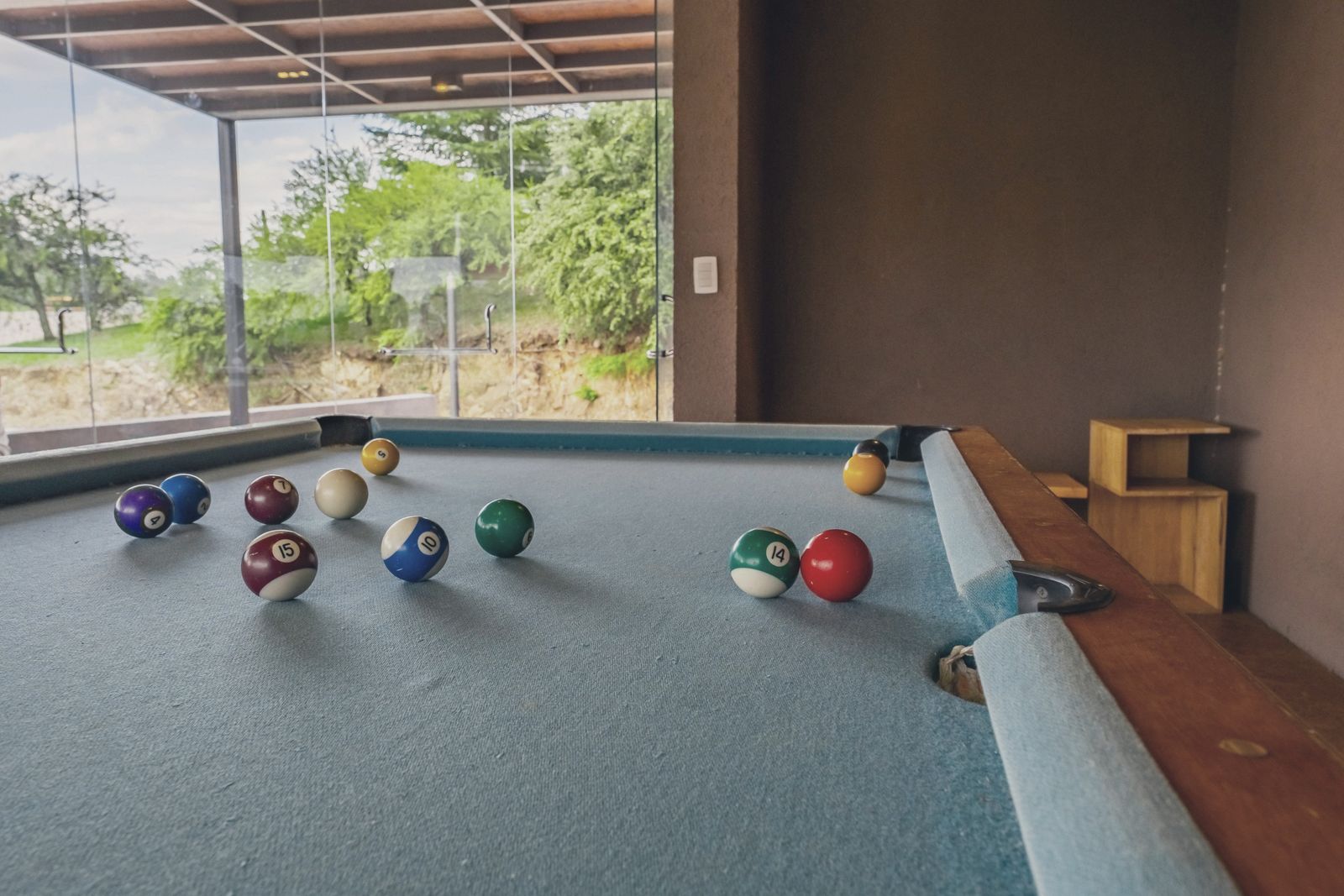 Sala de jogos com mesa de bilhar, pebolim e pingue-pongue